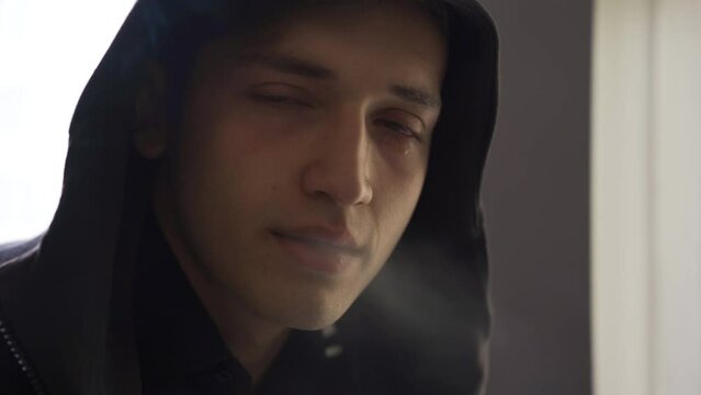 Lonely drug addict man crying and smoking marijuana.
Lonely and helpless young man crying, asking for help, smoking marijuana.
