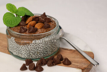 chia pudding with chocolate and almonds on white table
