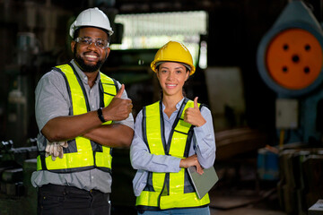 African American factory workers man and woman show thumbs up and look at camera with smiling...