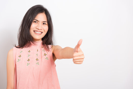 Portrait Asian beautiful young woman standing, She made finger thumbs up, Ok sign to agree and looking at camera, shoot photo in studio on white background, There was copy space