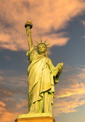 Fototapeta premium Statue of Liberty at sunrise in golden tones front view