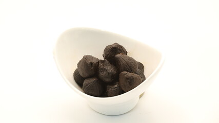 black garlic in a white cup