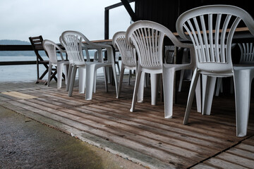 Closed restaurant, against the backdrop of a seascape. Empty terrace cafe, in a tourist town.