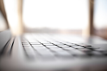Close-up of the keyboard of an open laptop ready to work on the table. Side view, selective focus...