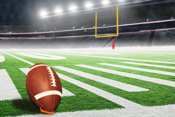  American football field goal post in fictitious stadium with ball on kicking tee ready for field...