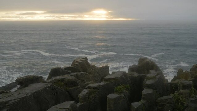 Stone strata over the ocean at sunset, in New Zealand