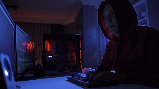 Background of male hacker using computer to commit crime.
Hacker bypasses cybersecurity by typing code on keyboard late at night.
