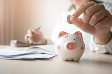 Money save concept woman put coin in piggy bank. Coin currency deposit for household expense.