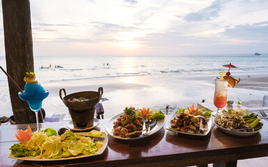 Dinner table during sunset on a beach with fish and Thai food.Romantic dinner table © Fokke Baarssen