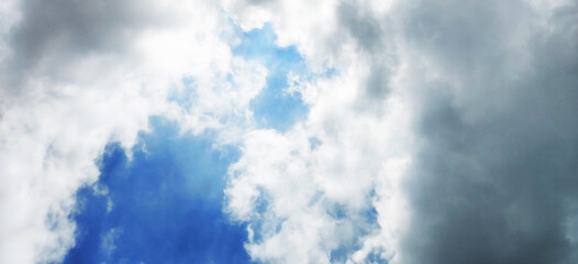 Beautiful clear light blue sky with white clouds in sunny day. Wallpaper background.