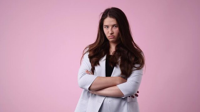 4k video of grumpy woman on pink background.
