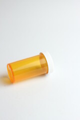 An empty orange pill bottle is placed on a white background.