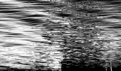 Reflection in a lake creates abstract patterns with light, shadows, and color. 