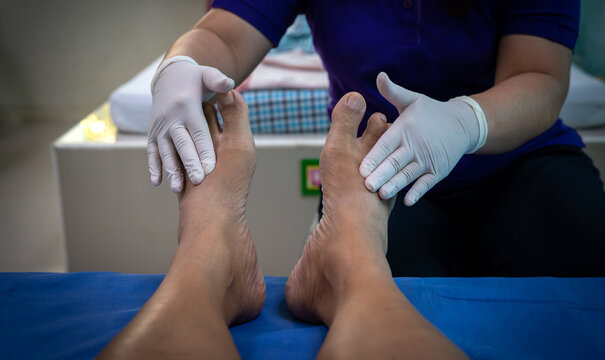 Specialists are examining the feet of patients in the hospital.Trauma surgeon specialist examine man foot on planned appointment in clinic