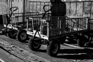 Metal wire carts are parked next to the outside wall and wood boardwalk.