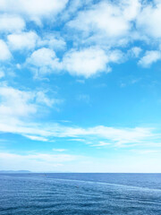 Naklejka na ściany i meble 真っ青な空に浮かぶ白い雲と海の地平線