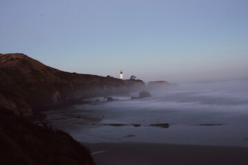 Sunrise at the Yaquina Head Lighthouse in Newport, Oregon.  The lighthouse is on a rocky...