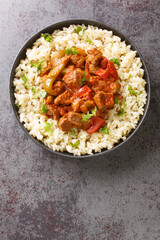 Porkolt is a classic Hungarian cuisine beef stew with onions and plenty of paprika close-up in a plate on the table. Vertical top view from above