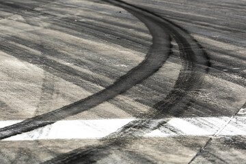 Background with tire marks on road track, Car track asphalt pavement background at the circuit, Abstract asphalt road background with crossing of tires tracks, Black tyre mark on asphalt road.