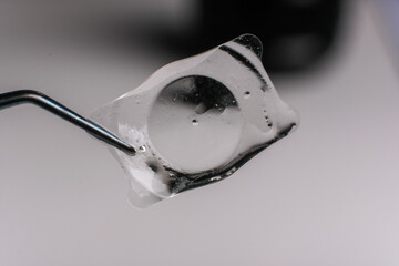 closeup photo of real eye lens removed from human suffering from cataract beside intra ocular lens