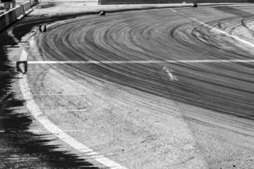Poster Background with tire marks on road track, Car track asphalt pavement background at the circuit, Abstract asphalt road background with crossing of tires tracks, Black tyre mark on asphalt road. © Darunrat
