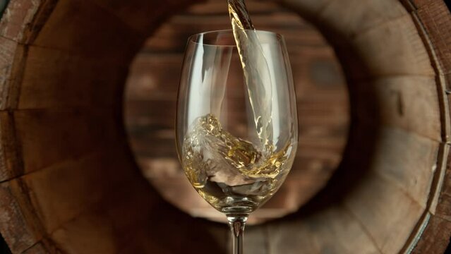 Super Slow Motion Shot of Pouring White Wine into Glass inside Wooden Barrel at 1000fps.