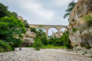 View on the Cesse river, the bridge, the "Grand Pont Naturel" cave and the medieval village of Minerve in the South of France (Herault)