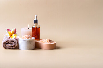 Holistic skin care still life . Natural oil bottle , salt scrab,candle, towel on beige backgrond....