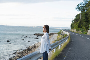 夕暮れの海岸線にいる女性