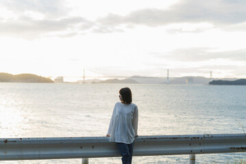 夕暮れの海にいる女性