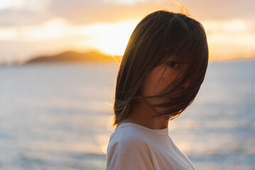 Obraz premium 夕暮れの海にいる女性