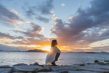 夕暮れの海にいる女性