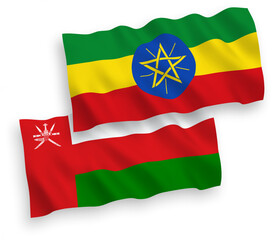 National vector fabric wave flags of Sultanate of Oman and Ethiopia isolated on white background. 1 to 2 proportion.