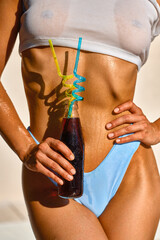 Close-up part of tanned female body and cool drink