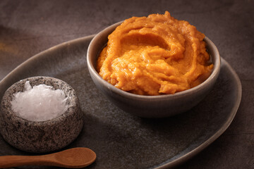 Homemade pumpkin purée for cooking in dark moody background