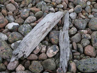 Fototapeta na wymiar driftwood and rocks on the beach at Jurmo island, Finland