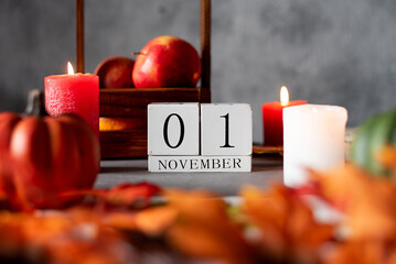 wooden calendar 1 st november. autumn decor apples candles and pumpkins