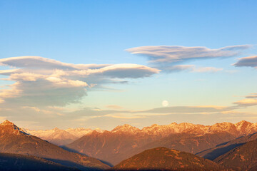 Fototapeta na wymiar Lenticular cloud above a the alps mountains and a full moon
