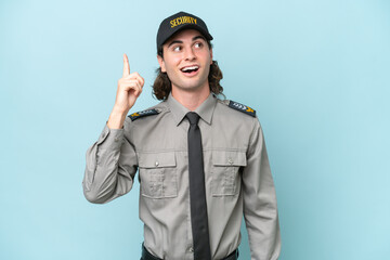 Young safeguard man isolated on blue background intending to realizes the solution while lifting a...