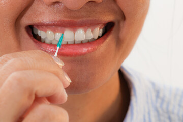 Woman holding using an interdental brush or a small brush specially designed to clean between ...