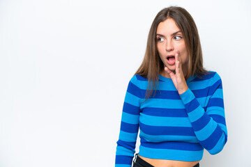 Young caucasian woman isolated on white background whispering something with surprise gesture while looking to the side