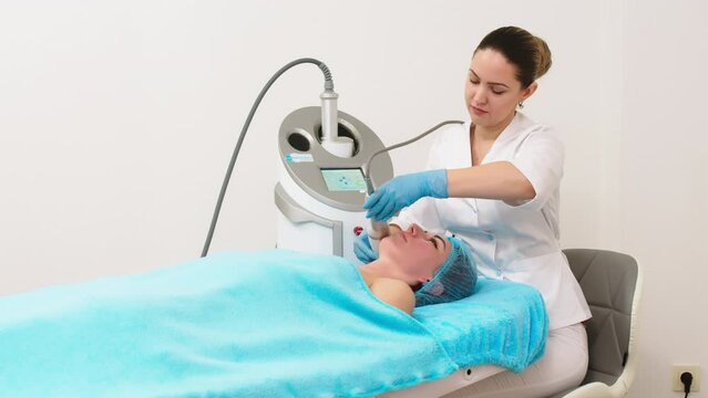 Why not pamper yourself with facial or body treatment. red haired woman with pefect freckled skin getting skin rejuvenation with RF lifting apparatus at at professional beauty salon, top view