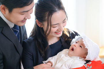 逆光は美しい赤ちゃんと一緒のお宮参りの様子　アップ