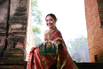 Portrait Beautiful Young Asia woman with Traditional Thai costume hold Banana leaf cockerel or Kra...