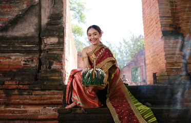 Portrait Beautiful Young Asia woman with Traditional Thai costume hold Banana leaf cockerel or Kra...