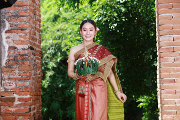 Portrait Beautiful Young Asia woman with Traditional Thai costume hold Banana leaf cockerel or Kra Thong in Thai , Loy Krathong Festival on November, pray respect water godness with godness