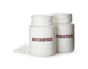Plastic bottles with antibiotic pills on white background