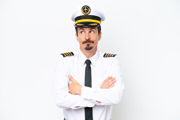 Airplane caucasian pilot isolated on white background making doubts gesture while lifting the shoulders