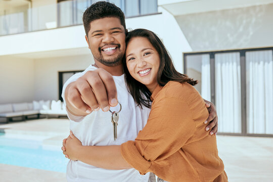 Homeowner, couple and show keys to new house, being happy and successful with smile, relax and hug. Portrait, black man and Asian woman celebrate, on property investment and embrace together outdoor.