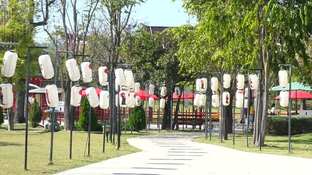 Traditional Japanese paper lanterns hang near pathway in thematic park